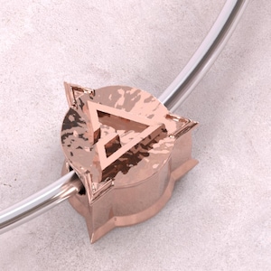 Könnte beinhalten: Eine Halskette mit einem Anhänger aus Roségold und einem gehämmerten Metallanhänger mit einem geometrischen Dreiecksmuster.