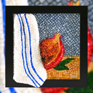 May include: A framed mosaic artwork depicting a red pomegranate with a white and blue striped towel in the background. The artwork is signed "SHTERN" in the bottom right corner.