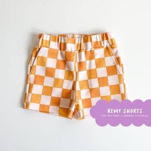 May include: Orange and white checkered shorts with a drawstring waistband and side pockets. The shorts are labeled "Remy Shorts PDF Pattern + Sewing Tutorial".