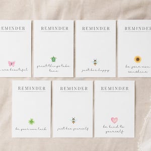 Puede incluir: Un conjunto de tarjetas de recordatorio blancas con mensajes inspiradores e ilustraciones pequeñas. Cada tarjeta presenta la palabra "REMINDER" en la parte superior y un mensaje e imagen diferentes, incluyendo una mariposa, tortuga, abeja, girasol, trébol y corazón.