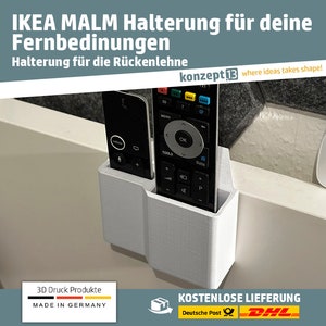 Puede incluir: Soporte de control remoto de plástico blanco con dos ranuras para controles remotos. El soporte está unido al lado de una superficie blanca. El texto "IKEA MALM Halterung für deine Fernbedinungen Halterung für die Rückenlehne konzept13 where ideas takes shape!" es visible en la parte superior de la imagen.