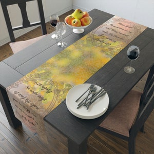 May include: A yellow and green table runner with a decorative frame and a bible verse, "May God be gracious to us and bless us; may He make His face to shine upon us. Psalm 67:1".