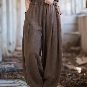 May include: Brown linen pants with a wide leg and elastic waistband. The pants are loose fitting and have a casual style.