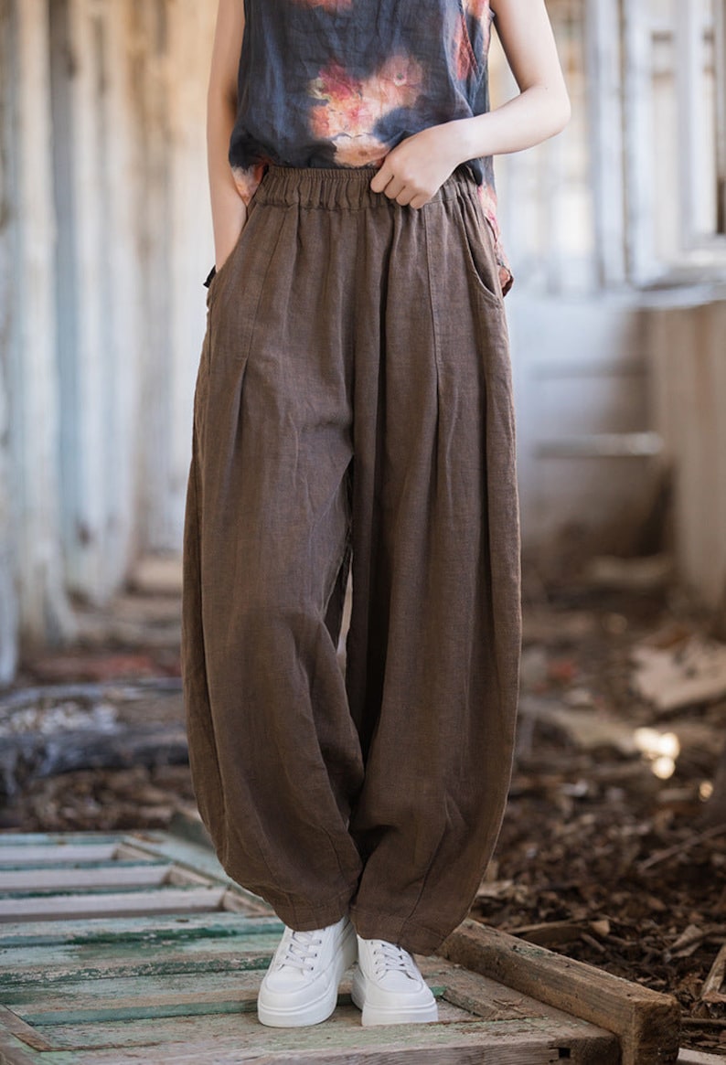 May include: Brown linen pants with a wide leg and elastic waistband. The pants are loose fitting and have a casual style.