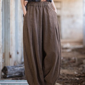 May include: Brown linen pants with a wide leg and elastic waistband. The pants have pockets on the sides and are made of a soft, comfortable fabric.