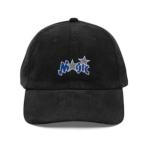 May include: A black corduroy baseball cap with an embroidered logo that says "Magic" with two stars.