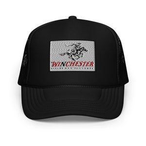 Può includere: Cappellino da camionista nero con una toppa bianca che presenta un'immagine in bianco e nero di un cavaliere a cavallo. La toppa include anche il testo "WINCHESTER RIFLES AND SHOTGUNS" in rosso.