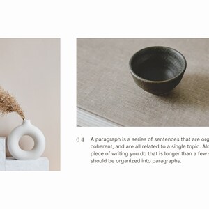 May include: A white ceramic vase with a ring-shaped opening, holding dried beige pampas grass. The vase is on a white platform, against a light beige background.
