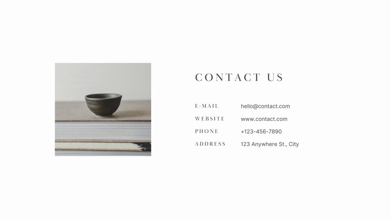 May include: A small, dark green ceramic bowl sits on top of a stack of books. The bowl is slightly tilted to the side. The books are stacked on a light brown surface. The text "CONTACT US" is displayed in a white font on a white background. Below the text, contact information is listed: "E-MAIL: hello@contact.com", "WEBSITE: www.contact.com", "PHONE: +123-456-7890", and "ADDRESS: 123 Anywhere St., City".