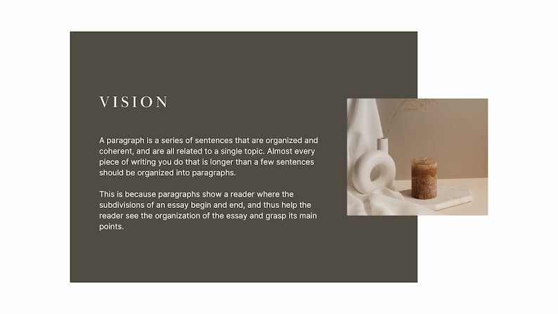 May include: A white ceramic vase with a circular opening sits on a white fabric surface next to a brown candle. The candle is on a white rectangular surface. The background is a light brown wall.