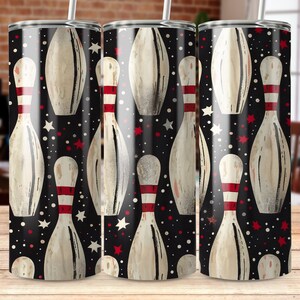 May include: Three stainless steel tumblers with a black background and a white bowling pin pattern. The bowling pins have red and white stripes.