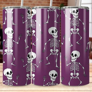 May include: Three purple stainless steel tumblers with a white skeleton design. The skeletons are dancing and have a fun, whimsical look.