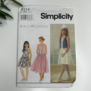 May include: Simplicity sewing pattern number 9314 for girls' dresses. The pattern includes three different styles: a floral print dress, a pink dress with a lace trim, and a white dress with a blue vest and lace trim. The pattern is designed by Jessica McClintock.