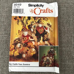 May include: Simplicity Crafts pattern featuring scarecrow dolls. The pattern includes instructions for making scarecrows with straw hair, sunflower accents, and plaid clothing. The package is labeled "One Size" and includes the designer's name, Faith Van Zanten.