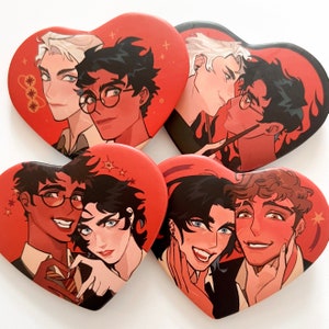 Puede incluir: Cuatro botones en forma de corazón con ilustraciones de personajes masculinos. Los botones tienen un fondo rojo con ilustraciones en tonos marrones, negros y blancos. Cada botón representa a dos personajes en varias poses.