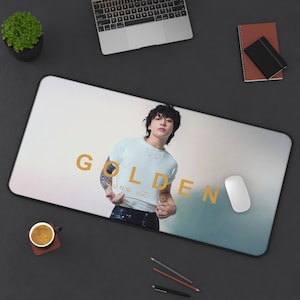 Könnte beinhalten: Eine weiße Mausmatte mit einem hellblauen und weißen Verlaufshintergrund. Der Text "GOLDEN" ist in goldenen Buchstaben gedruckt. Ein Mann mit dunklen Haaren trägt ein weißes T-Shirt mit dem aufgedruckten Text "YOUNG & FREE". Er steht vor einem hellblauen und weißen Verlaufshintergrund.