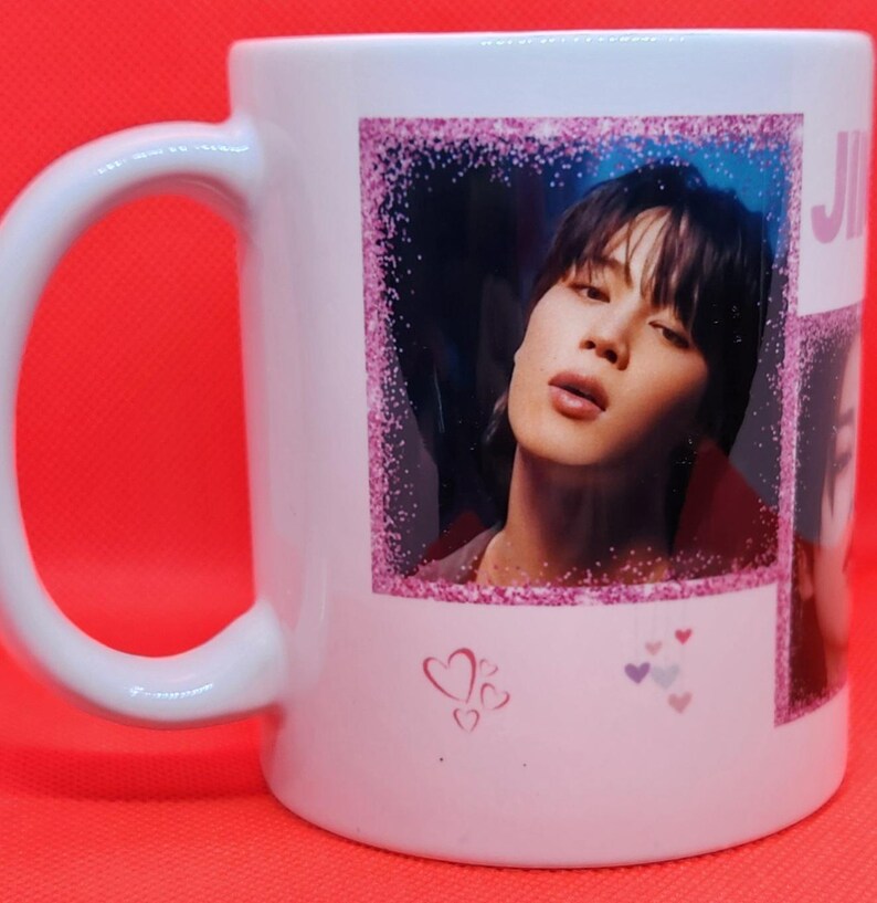 May include: White ceramic mug with a pink glitter border around a photo of a man with dark hair. The photo is surrounded by pink hearts.