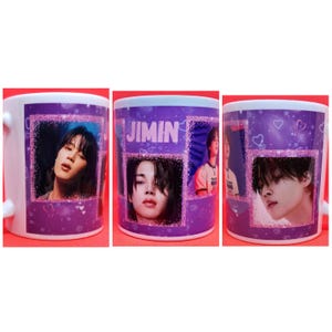 May include: A white ceramic mug with a purple background and a glittery design. The mug features images of a young man with dark hair and the word "JIMIN" in pink letters.