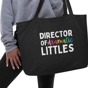 May include: Black tote bag with white text that reads "DIRECTOR OF dramatic LITTLES" in rainbow colours.