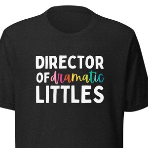 May include: Black t-shirt with white text that reads "Director of dramatic littles". The word "dramatic" is in rainbow colours.