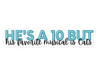 Peut inclure: Un autocollant blanc avec le texte "HE'S A 10 BUT his favorite musical is Cats" en bleu et noir. Le texte est disposé horizontalement sur l'autocollant.