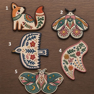 May include: Five embroidered patches featuring animal and floral motifs. Number 1 is a fox, 2 is a moth with pink flowers, 3 is a bird, 4 is a curved floral shape, and 5 is a moth with moon and star details. Each patch has intricate colorful stitching.