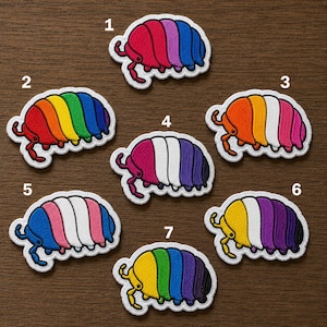May include: Seven embroidered patches shaped like pill bugs, each featuring different colored stripes. The patches are numbered one through seven, displaying various color combinations including rainbow, pink, white, purple, orange, and blue patterns.