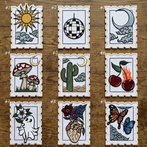 May include: Nine embroidered patches with various designs, including a sun, disco ball, moon, mushrooms, cactus, cherries, ghost, anatomical heart, and butterflies. Each patch is rectangular with a postage stamp-like border and features detailed stitching.