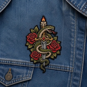 May include: Embroidered patch featuring a green snake coiled around a sword, with red roses and green leaves. A lit candle is at the top. The patch is on a blue denim jacket.