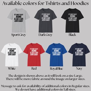 Funny Gift for Husband - This image shows the 7 colors that our Tshirts and hoodies are available in.  The Black, White, Sport Grey, Dark Grey Heather, Red, Royal Blue, and Navy Blue shirts include text saying "It's not easy being my wife's arm candy" - we carry TShirts and Hoodies in Big sizes 3XL, 4XL, 5XL, and 6XL and Tall sizes LT, XLT, 2XLT, 3XLT, and 4XLT