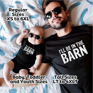 May include: Black t-shirts and onesie with the text "I'LL BE IN THE BARN" and "I'LL BE IN THE BARN TOO". The baby is wearing sunglasses. Regular sizes XS to 6XL, Tall sizes LT to 4XLT, and Baby, Toddler and Youth sizes are available.