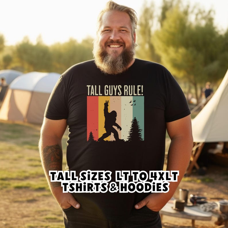 Puede incluir: Camiseta negra con el texto "TALL GUYS RULE!" y un gr&aacute;fico retro de una silueta de Bigfoot haciendo el signo de la paz. La camiseta tambi&eacute;n tiene el texto "TALL SIZES LT TO 4XLT TSHIRTS & HOODIES".