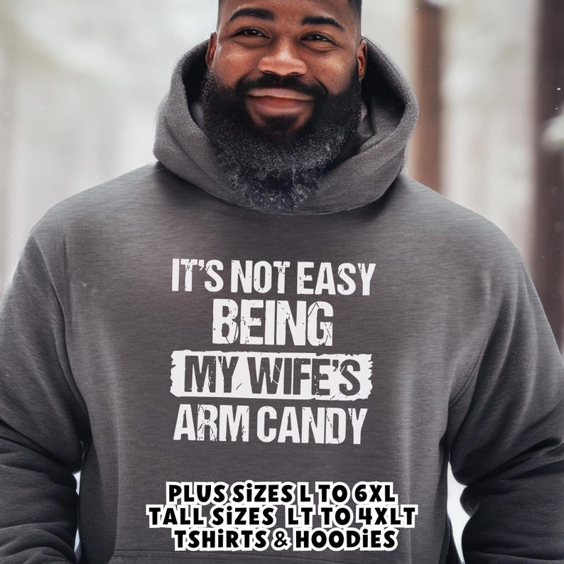 Funny Gift for Husband - a pullover hoodie sweatshirt with text saying "It's not easy being my wife's arm candy" - image includes a text overlay saying that we carry TShirts and Hoodies in Big sizes 3XL, 4XL, 5XL, and 6XL and Tall sizes LT, XLT, 2XLT, 3XLT, and 4XLT