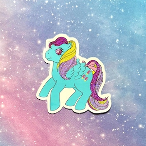 May include: A sticker featuring a cartoon pony with a light blue body, yellow and purple hair, and a pink bow. The pony has wings and a gem on its eye. The background is a gradient of pink, blue, and white with glitter.
