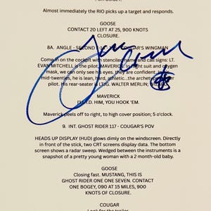 Può includere: Una pagina della sceneggiatura del film "Top Gun" con note manoscritte e firme. Il testo include dialoghi e descrizioni di scene, con i nomi "Maverick" e "Goose". La pagina è firmata con inchiostro blu.