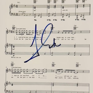 May include: Sheet music featuring musical notation, lyrics, and chord symbols, with a blue ink signature. Lyrics include phrases such as "I wanna be your vacuum cleaner" and "I wanna be your Ford Cortina."