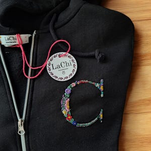 Sweatshirt mit Anfangsbuchstaben mit bunten handgestickten Blumen