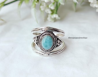 Può includere: Un anello d'argento con una pietra ovale blu chiaro al centro. L'anello ha un design a strati con dettagli intricati attorno alla pietra. Il testo "Shreejaipurjewels92" è visibile sul lato destro.