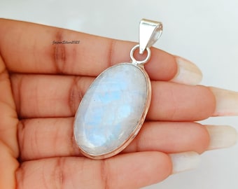 May include: A silver pendant with a large oval moonstone. The moonstone is white with a blue iridescent sheen.