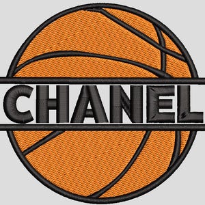 May include: Embroidered basketball design with the name "CHANEL" in black block letters. The basketball is orange with black lines and a black border. The name is centered on the ball.