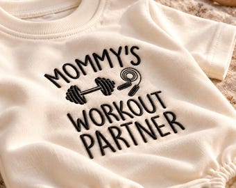 Geborduurde babyromper met de tekst "Mommy's Workout Partner" | Gym babybody, fitness babyoutfit, kraamcadeau met gewichthefthema, cadeau voor pasgeborene