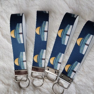 May include: Four blue and white keychains with a gold dome design. Each keychain has a silver key ring.