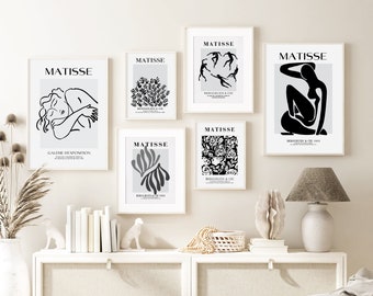 May include: Five black and white framed prints of Matisse artwork with the title "MATISSE" and the text "BERGGRUEN & CIE" on a white wall. The prints are arranged in a grid pattern. The prints feature abstract designs and figures.