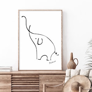 Op de afbeelding: Een zwart-witte lijntekening van een olifant van Pablo Picasso. De tekening is ingelijst in een licht houten lijst en hangt aan een witte muur.