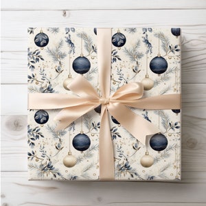 May include: A wrapped gift with cream-coloured wrapping paper featuring a pattern of navy blue and gold Christmas baubles and foliage. A cream-coloured satin ribbon is tied in a bow around the gift.