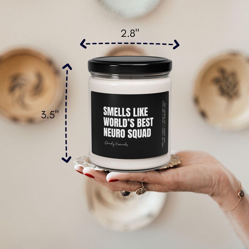 K&ouml;nnte beinhalten: Eine wei&szlig;e Kerze mit einem schwarzen Etikett, auf dem "Smells like world's best neuro squad" steht. Die Kerze ist 3,5 Zoll hoch und 2,8 Zoll breit.