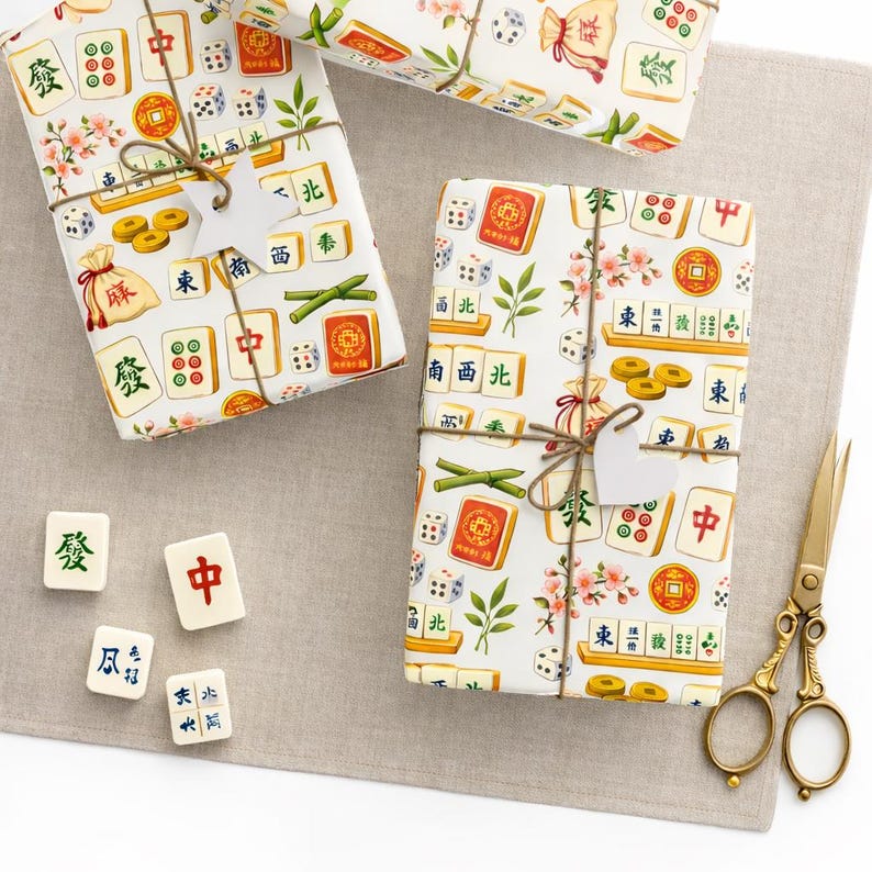May include: Gift-wrapped presents with a white background and a colorful Mahjong tile pattern. The gifts are tied with twine and adorned with small tags. Scattered Mahjong tiles and gold scissors complete the scene.