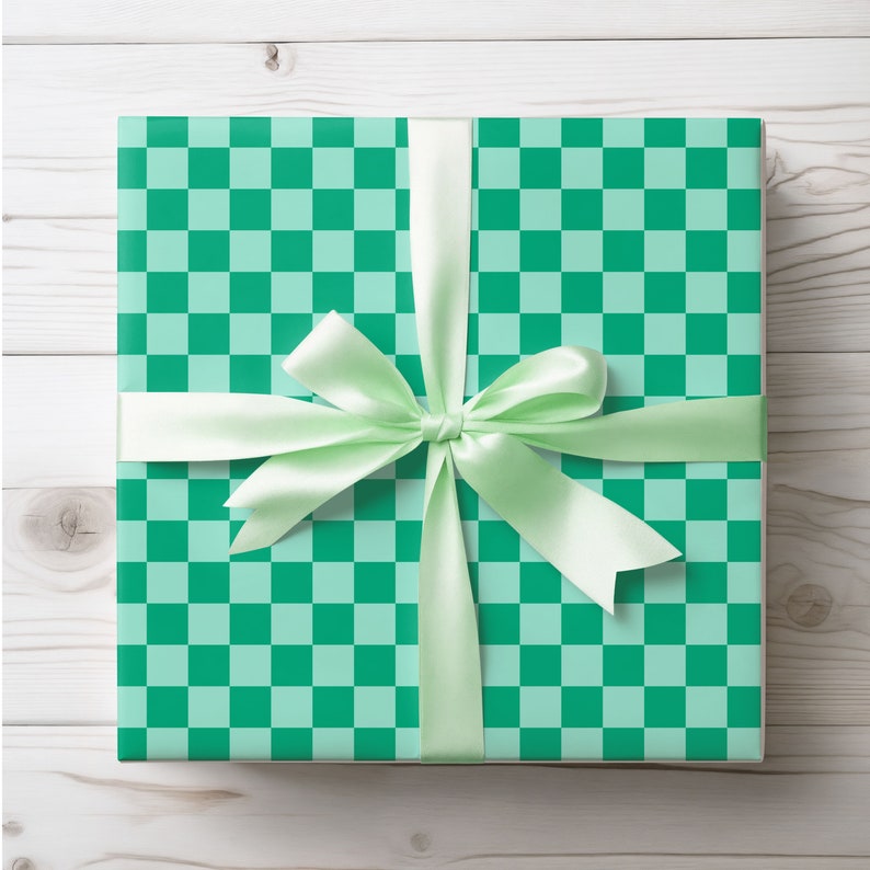 Op de afbeelding: Een groene en lichtgroene geruite cadeaudoos met een lichtgroen satijnen lint gebonden in een strik.