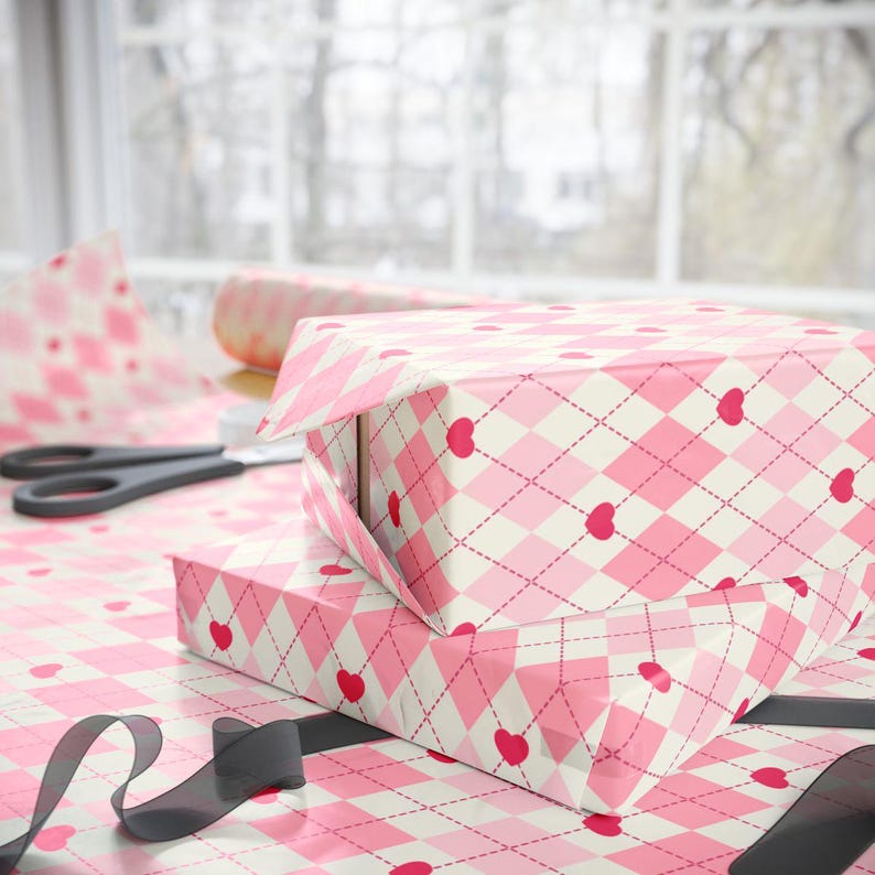 May include: Two pink and white gift boxes with a pink and white argyle pattern and red hearts. The boxes are wrapped in pink and white patterned paper.
