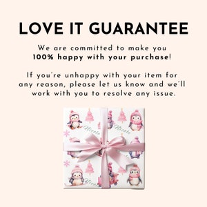 May include: A wrapped gift with a white background featuring a pattern of penguins wearing pink hats and scarves, pink Christmas trees, and snowflakes. The gift is tied with a pink satin ribbon. The text "Nicole" is printed on the wrapping paper.